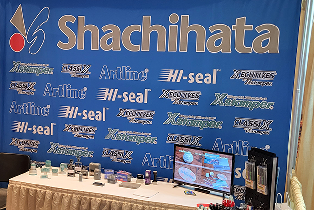 Shachihata's booth with screen and products