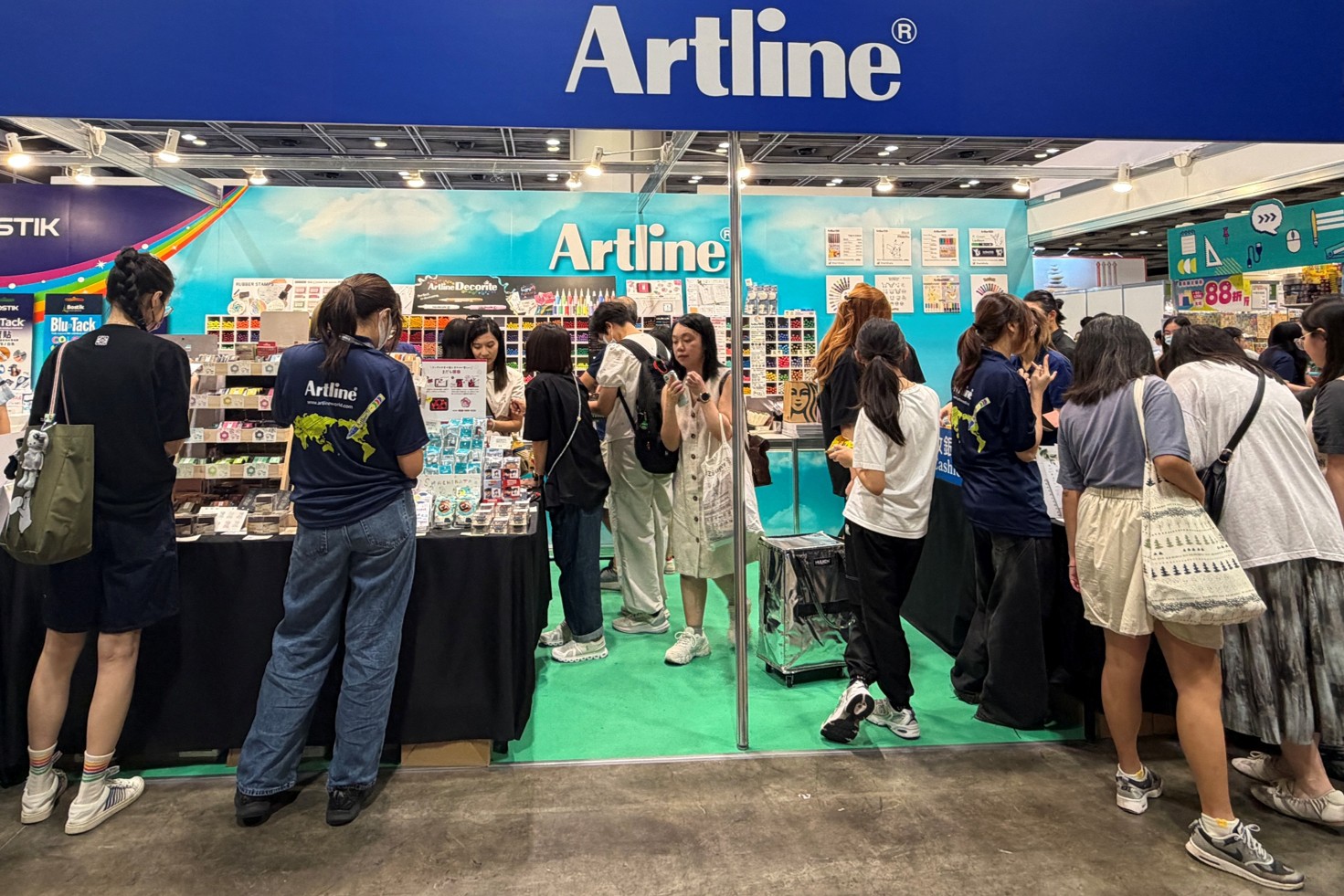 People are gathered at the Artline booth.