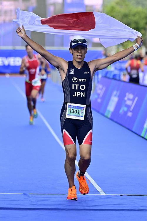 A man is running holding a Japan flag in his hands