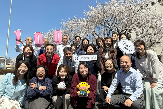 Employees celebrating 100th anniversary with balloons and cherry blossoms