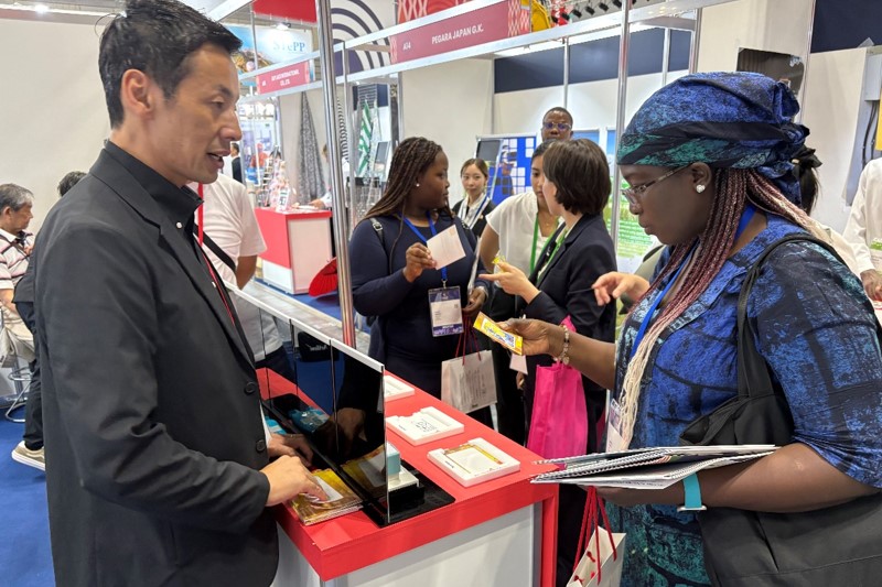 Visitors receiving an explanation of the Ukiyo-e Layer Stamp Kit from Shachihata staff