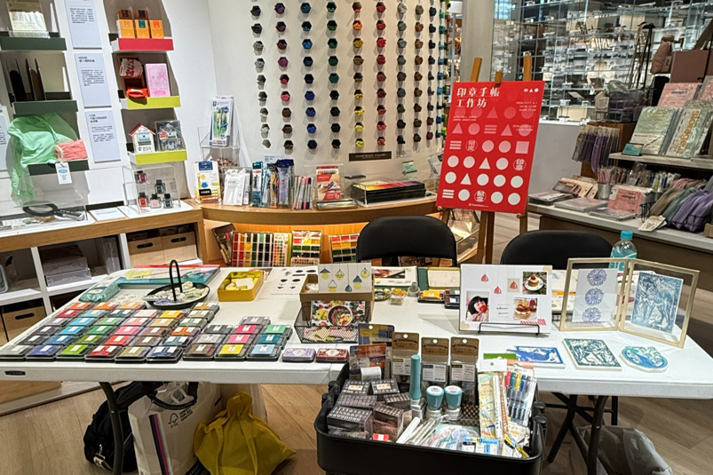 Display table featuring IROMOYO ink pads and sample eraser stamp artworks.