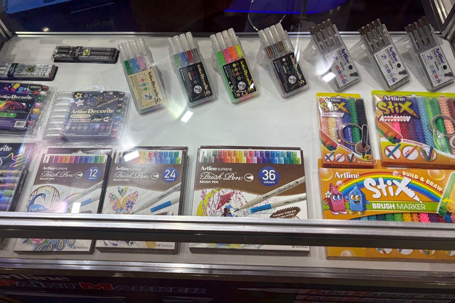 A scene showing item such as Artline Decorite and the Artline SUPREME Blush Pen on display.